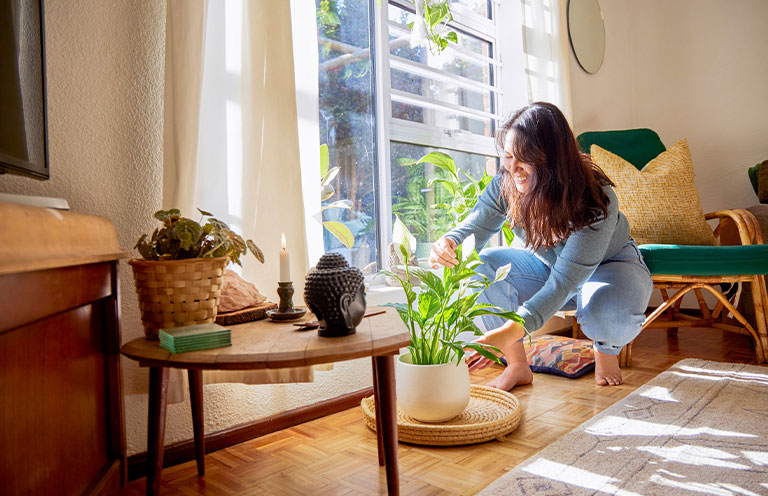 woman tending to floor plant