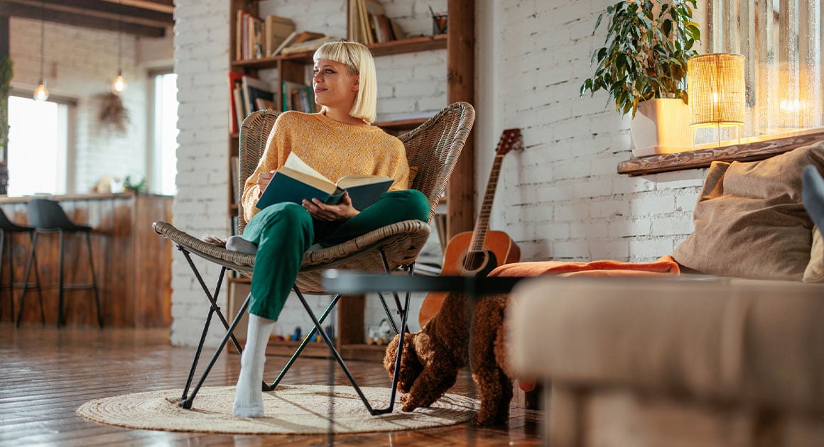 woman sitting in chair reading a book