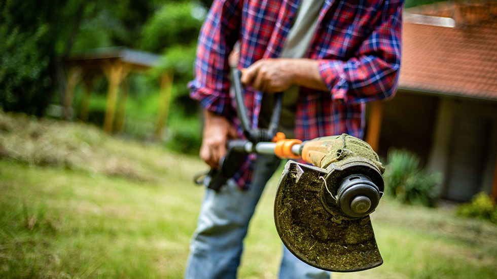 man using a weed wacker 