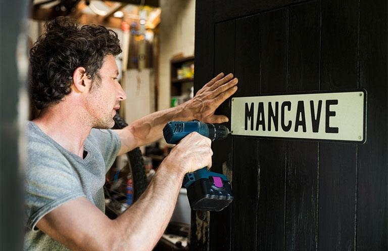 man installing Mancave sign