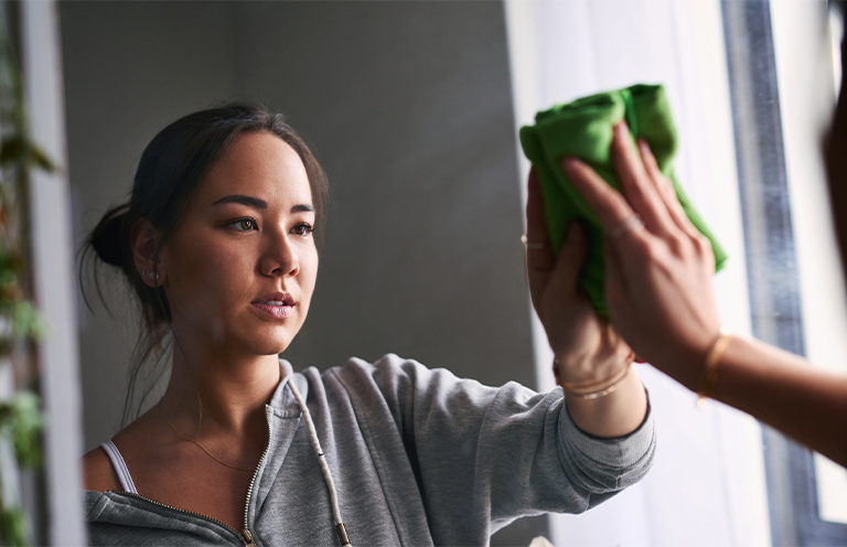 Woman cleaning mirror