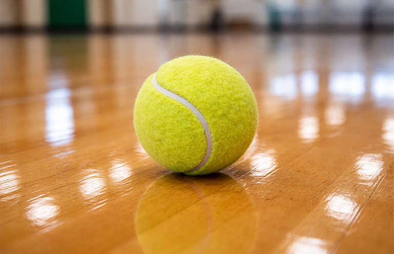 Tennis ball on waxed floor