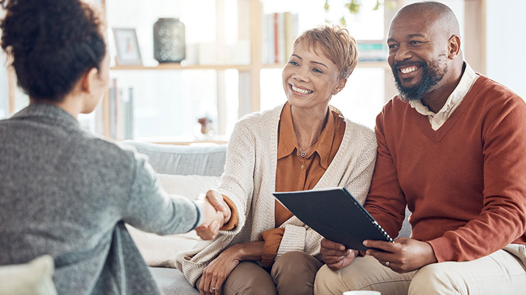Business meeting, welcome handshake and couple meet with lawyer or financial advisor. Elderly married man, wife and woman retirement conversation, planning and insurance documents for estate finance; By Wesley J/peopleimages.com