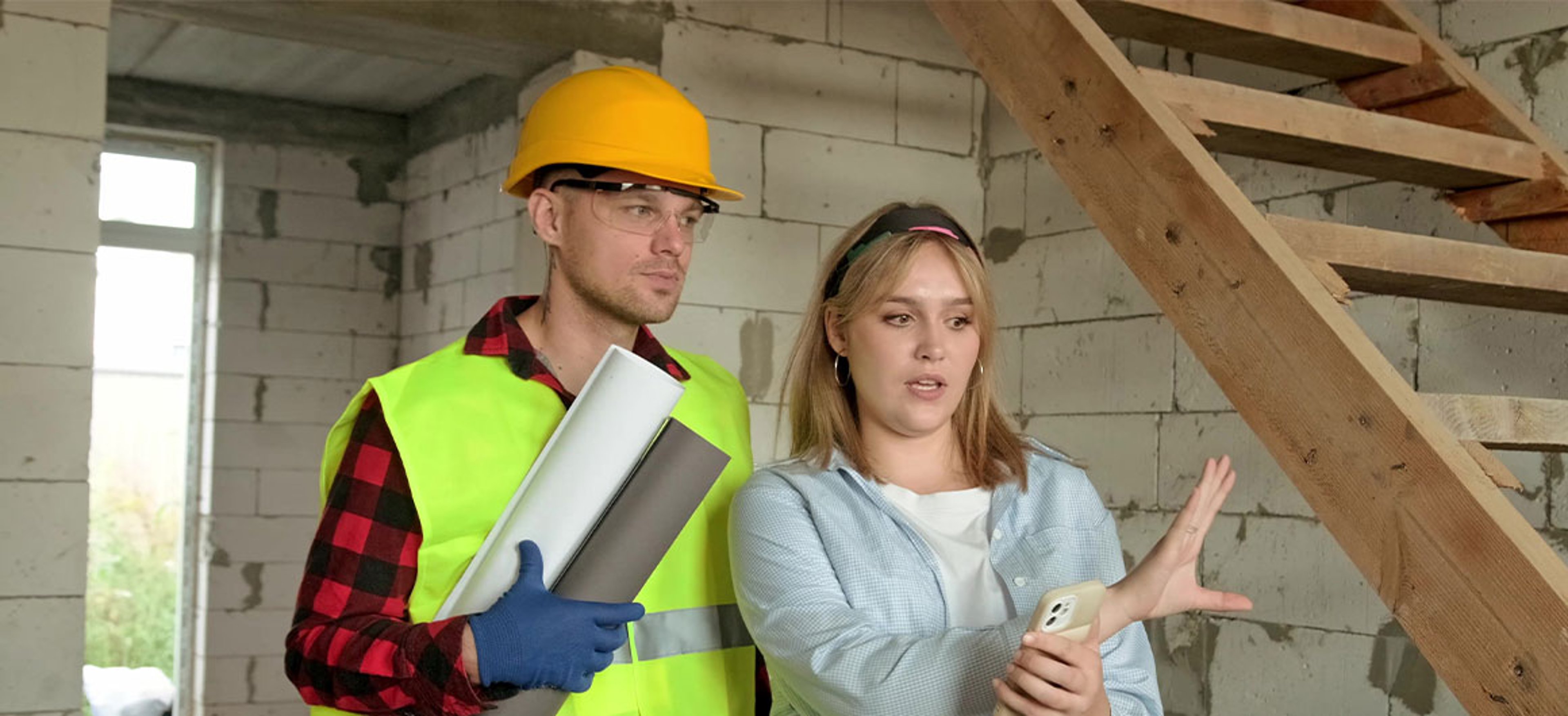 woman showing contractor unfinished room 