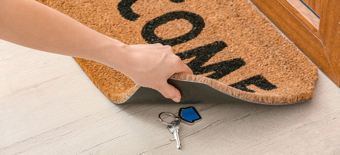 house key under a welcome mat