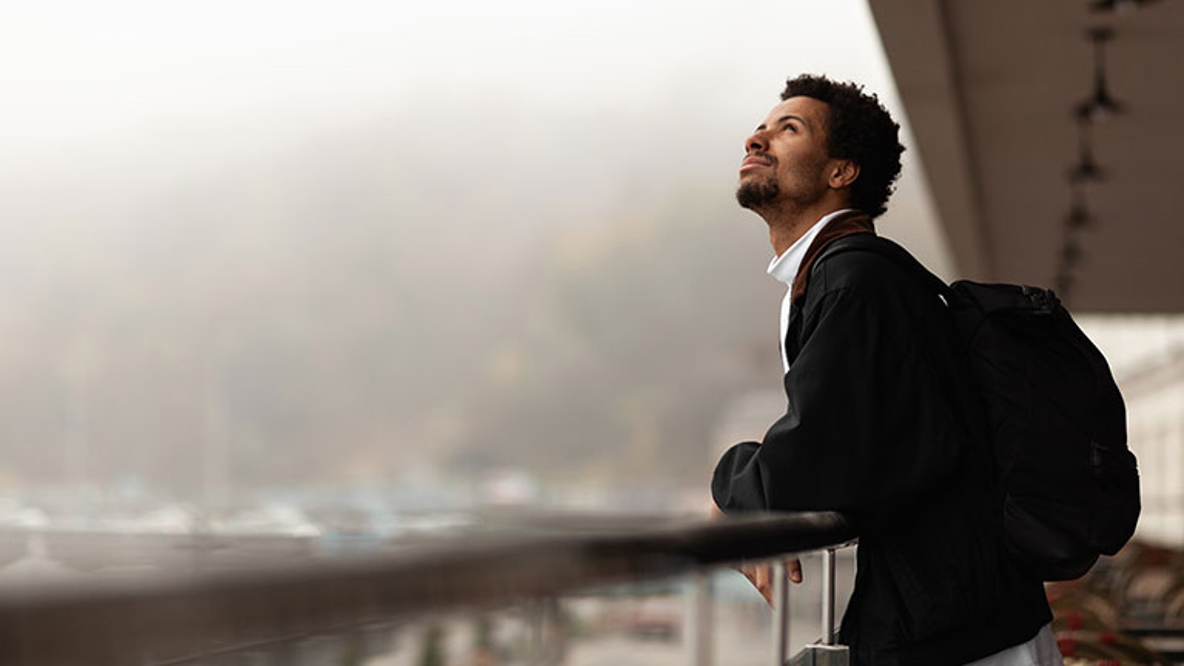 African man looks at clouds with displeasure, nasty weather, poor forecast.  by Andrii Zastrozhnov