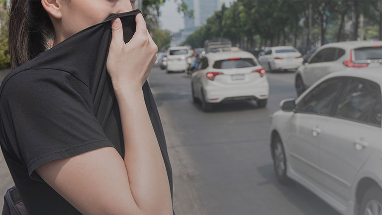 woman closes her nose with hand because of bad traffic pollution Credit:Werawad Ruangjaroon