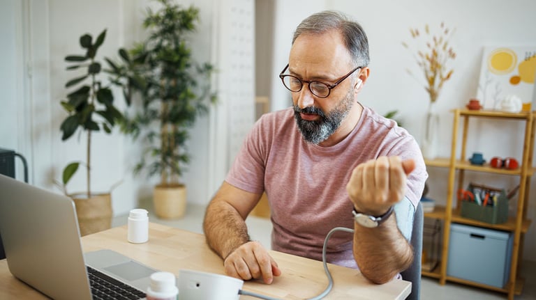 Man checking blood pressure during a virtual doctor appointment 