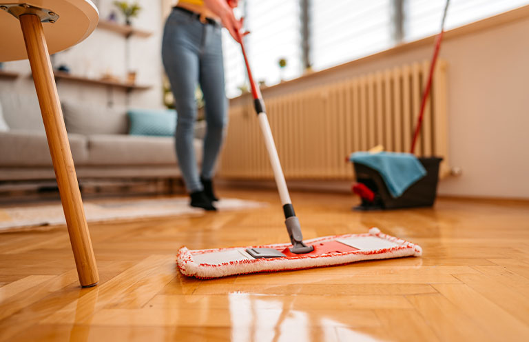 woman cleaning floor with wet mop