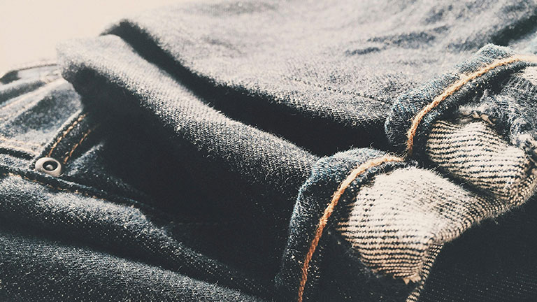 Folded Blue Denim Bottoms on Brown Surface Credit: Snapwire