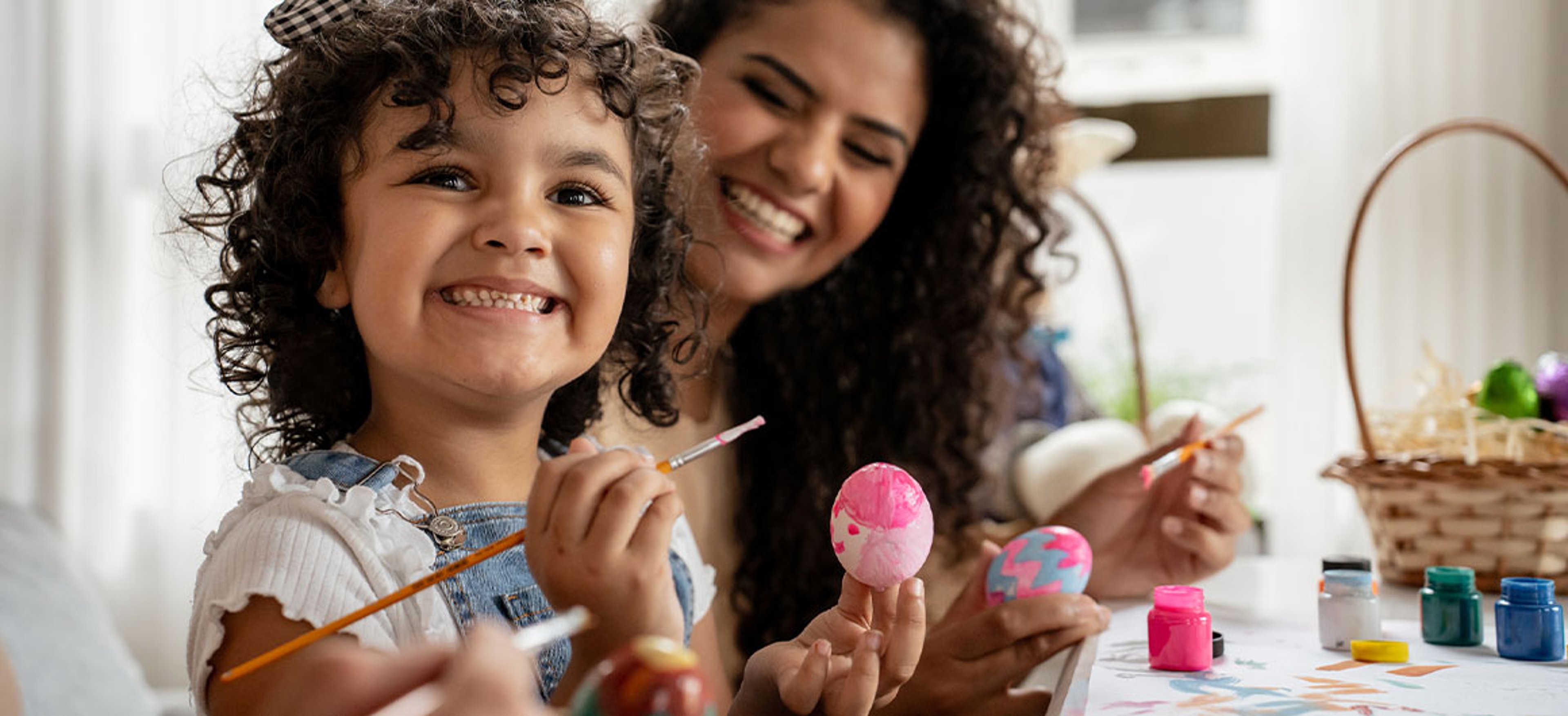 mother and daughter painting easter eggs