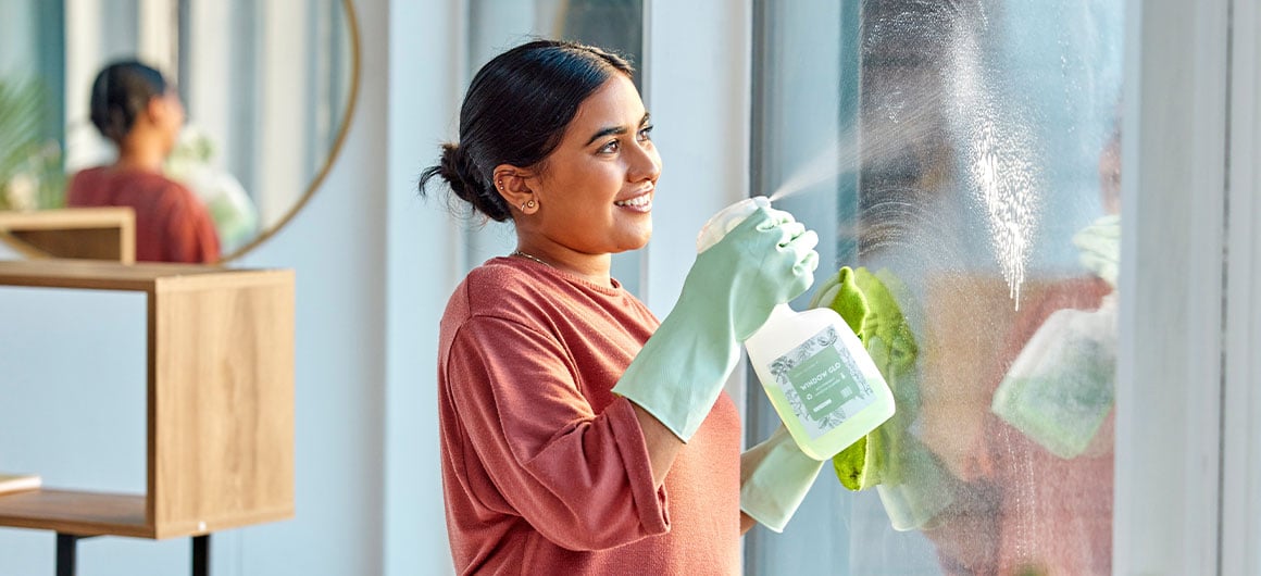 woman spraying and cleaning windows