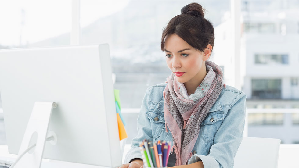 woman in casual outfit sitting at her desk