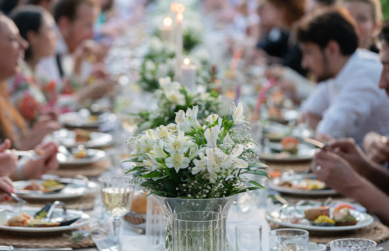 Group of people having dinner at wedding reception table
