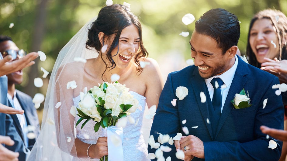 Guests throwing confetti over bride and groom as they walk past after their wedding ceremony