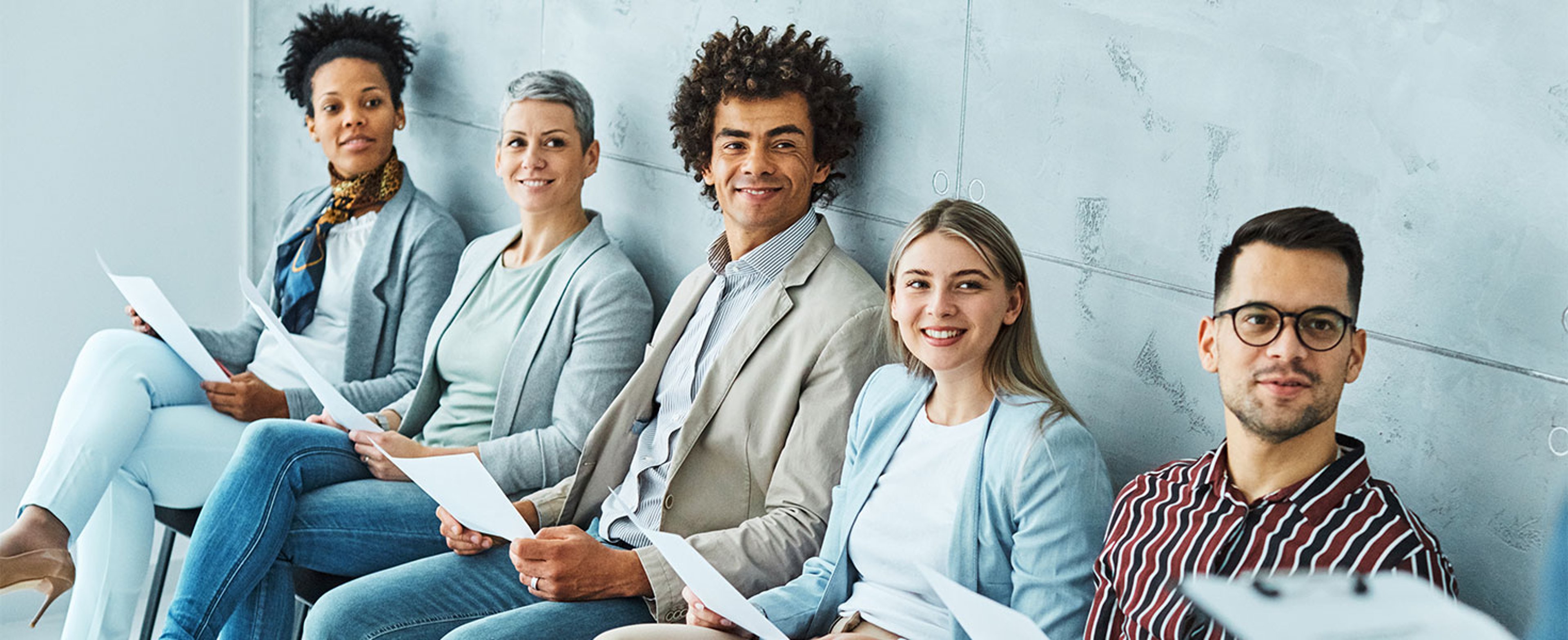 Job candidates sitting with resumes in hand