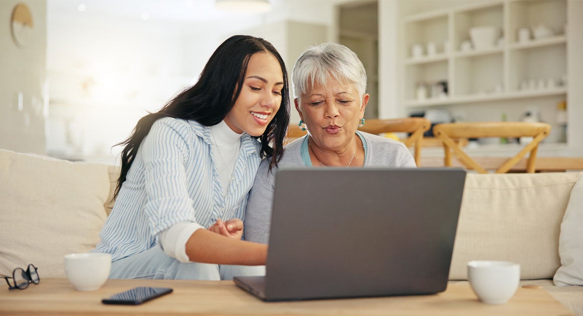 young adult and elder woman looking at laptop