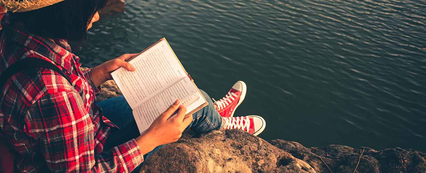 Girl reading by the water
