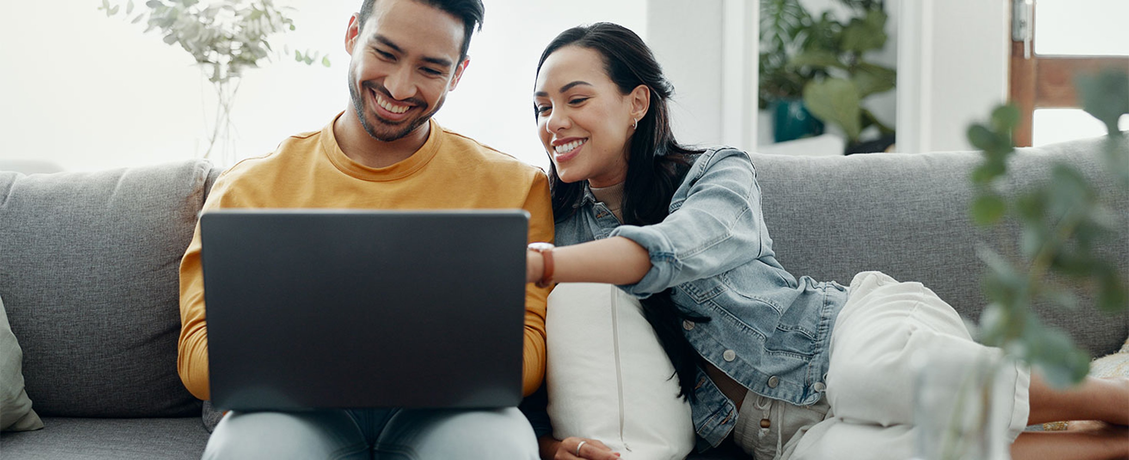 man using laptop, woman smiling next to him