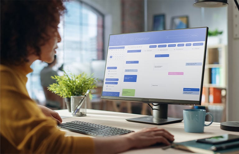 woman looking at calendar on computer