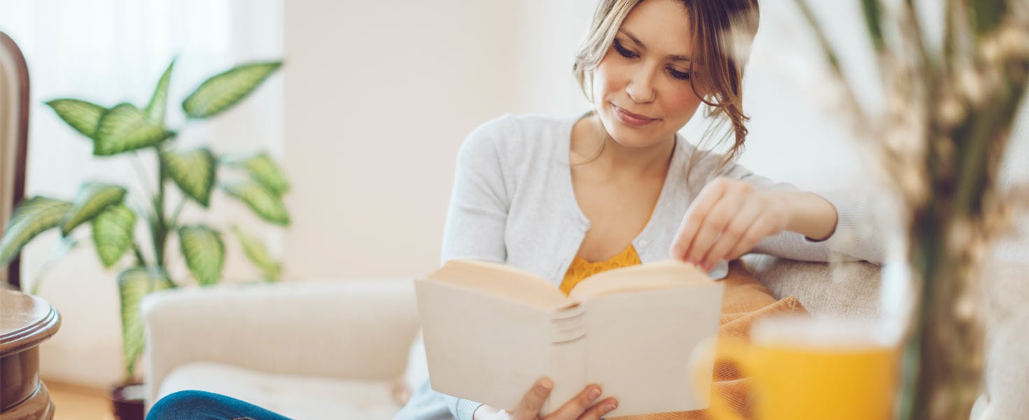 Woman reading a book with a white cover