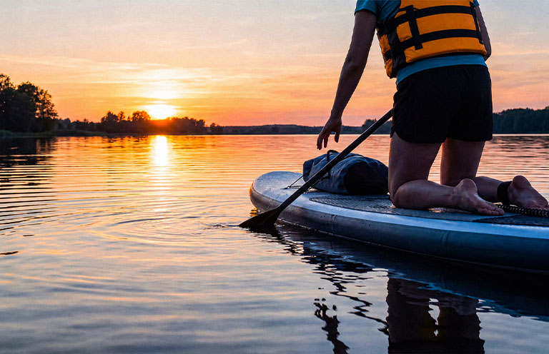 person kneeling on a paddleboard