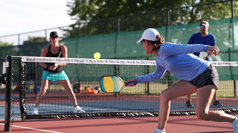 pickleball game, relaxing pickleball players couple with yellow ball with paddle sitting after game, outdoor sport leisure activity. by Sergei