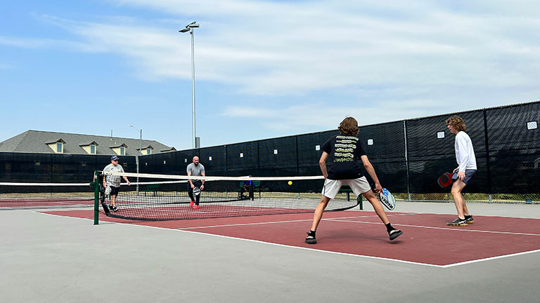 pickleball game, relaxing pickleball players couple with yellow ball with paddle sitting after game, outdoor sport leisure activity. by Sergei