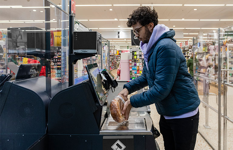 man using self checkout for bread