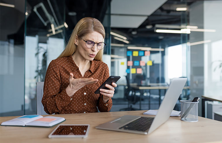 woman holding phone and looking at it with confused expression
