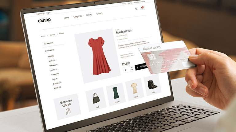 Shopping online with credit card concept. Modern e-commerce web page with woman clothes on laptop display By Stanisic Vladimir
