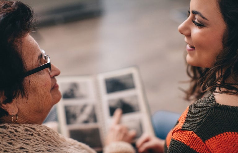 mother and daughter looking at family photo albums