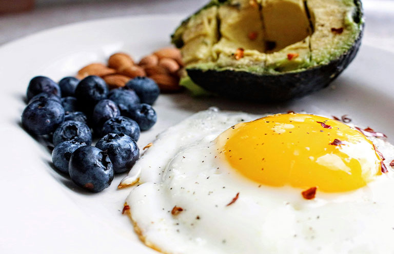 blueberries avocado and egg on a plate