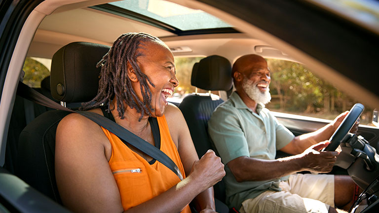 Senior Couple Enjoying Summer Day Trip Out Driving In Car Together; Credit: monkeybusinessimages