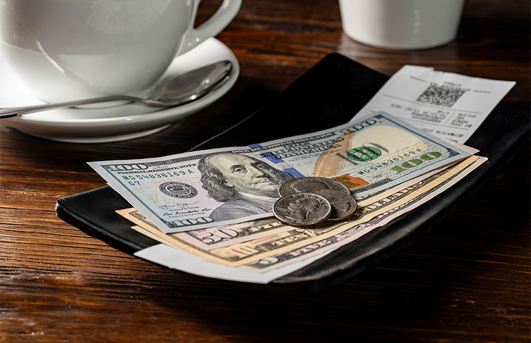 tip being left on table with coffee cup