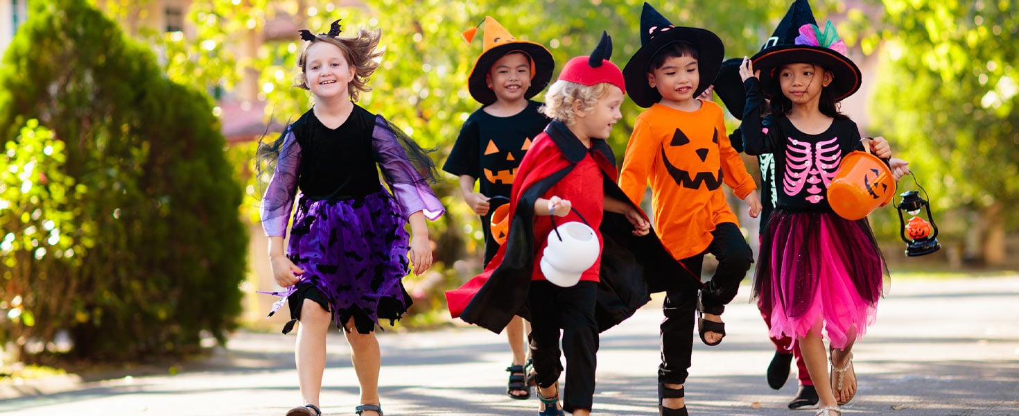 Children in Halloween costumes walking down the street