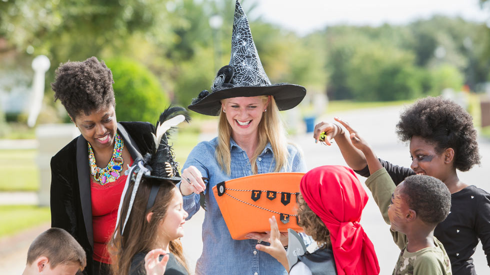 Parents giving out candy on Halloween