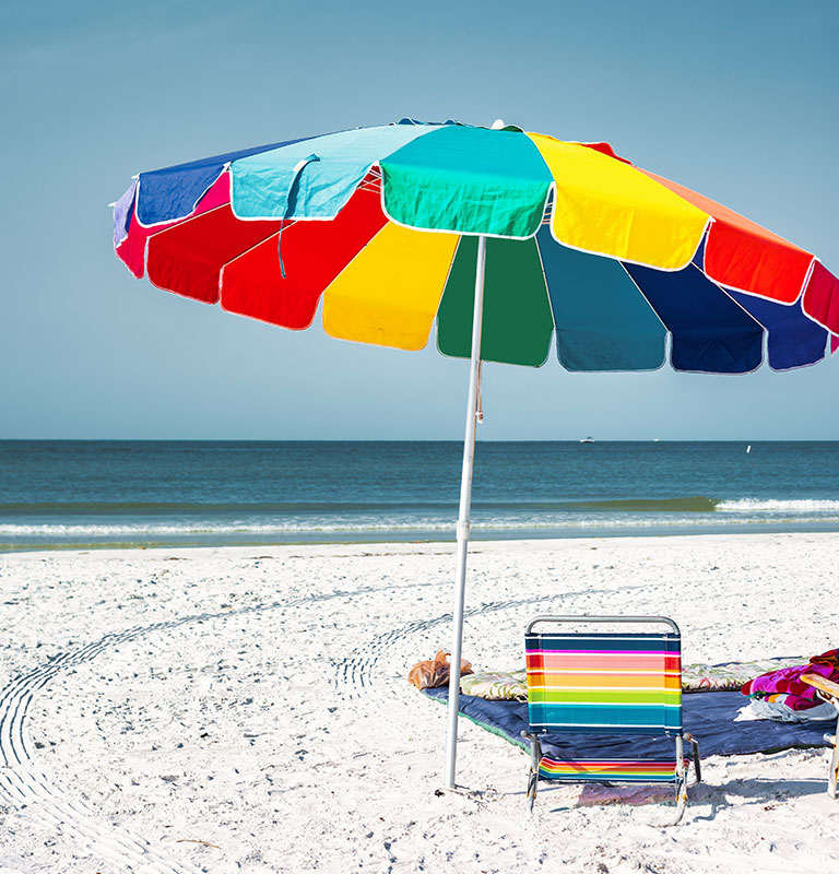 Rainbow Colored Sun Umbrella in Fort Myers Beach, Florida, USA on a sunny day; Credit: benedek