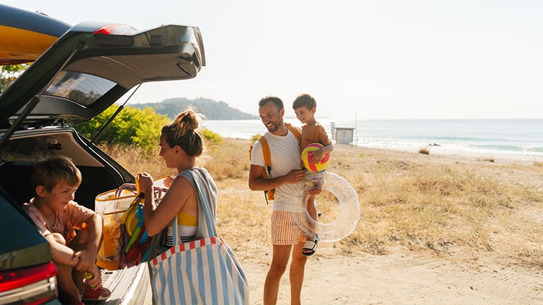 Photo of an adventurous family with two young boys, on a summer road-trip with a family car, found a perfect local beach to spend a hot summer day; Credit: AleksandarNakic