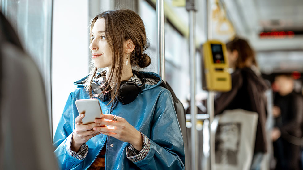 Young woman with headphones using public transport.