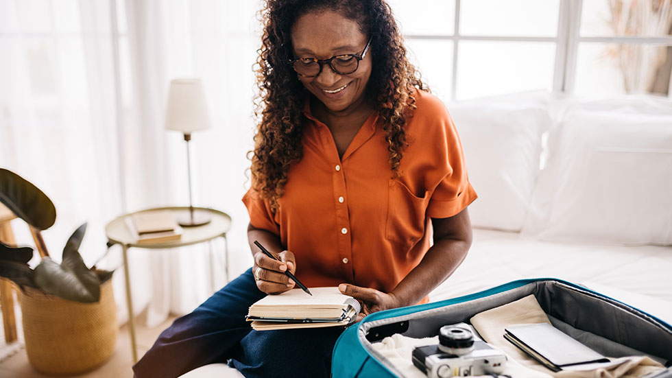 Senior woman getting ready for a vacation with a packing list.