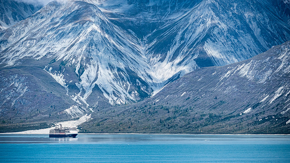 Holland America Line cruise ship sailing through Alaskas Glacier Bay National Park in late summer. photo courtesy of Urbanglimpses/iStock.com