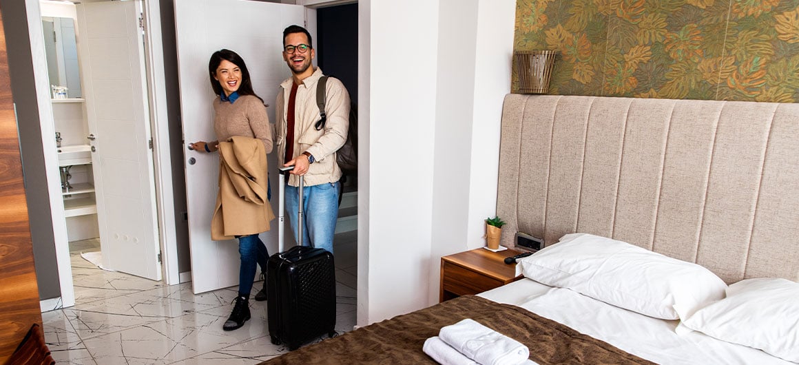 man and woman walking into hotel room