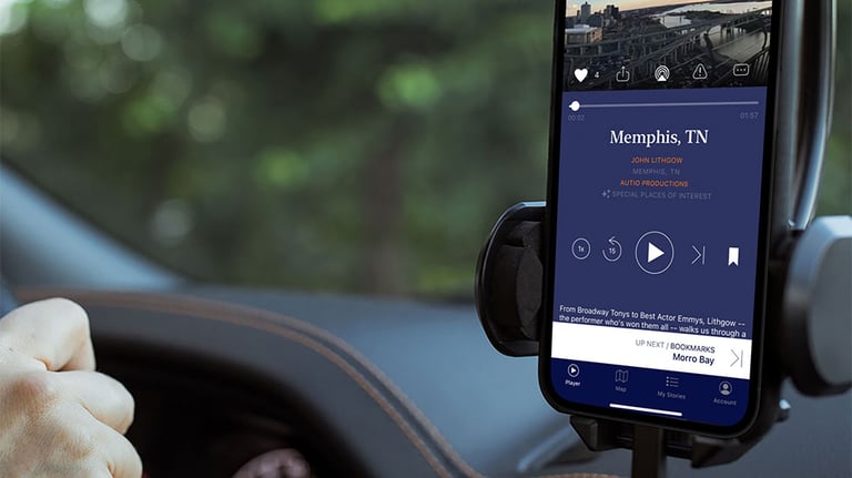 Autio app open on smartphone attached to dashboard inside of car