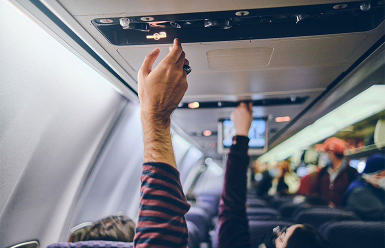 man adjusting airplane air vents