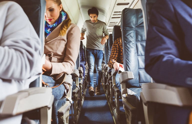 man walking down airplane isle