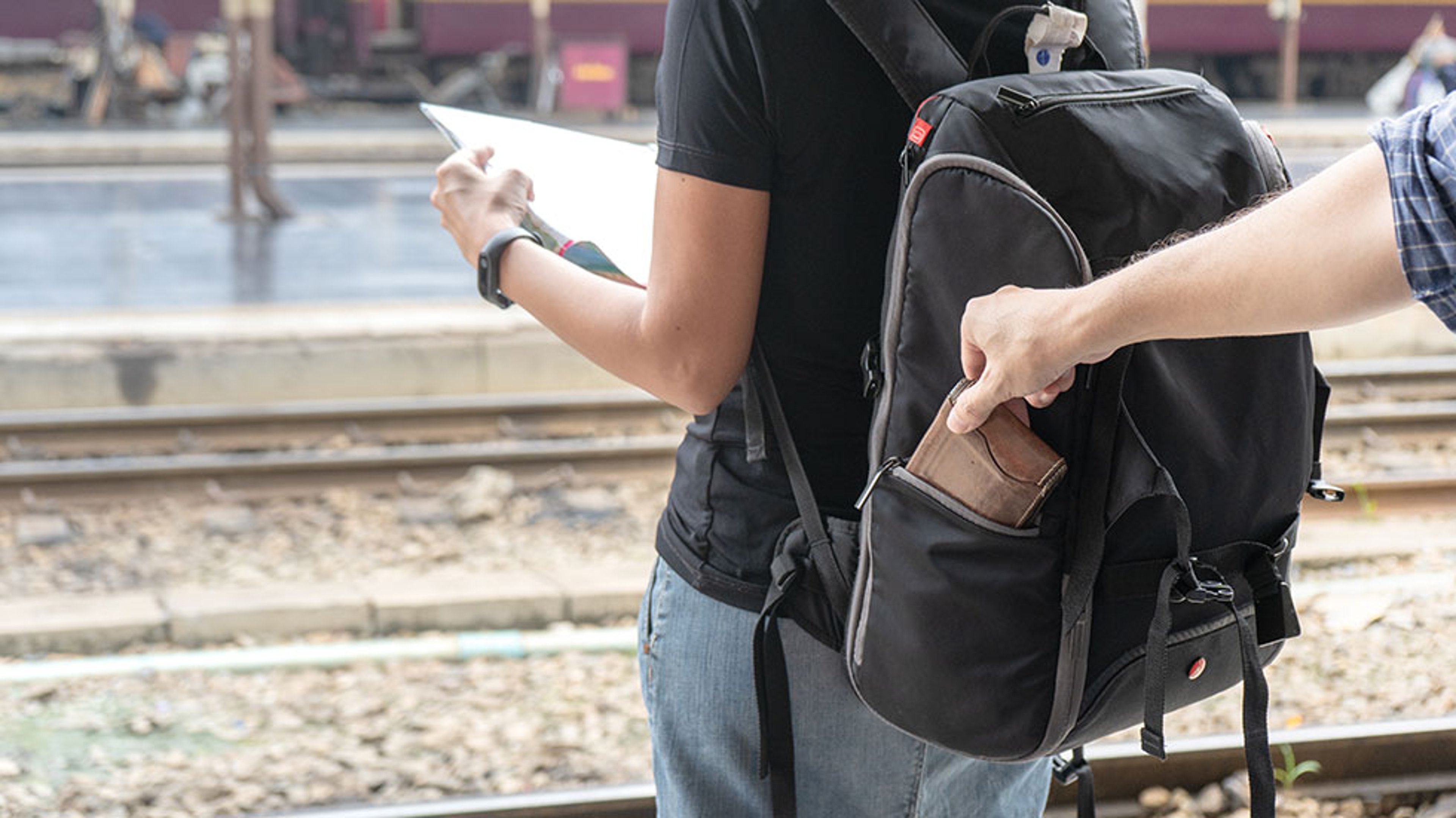 Downloaded Street thief stealing a wallet from woman tourist backpack by supakit