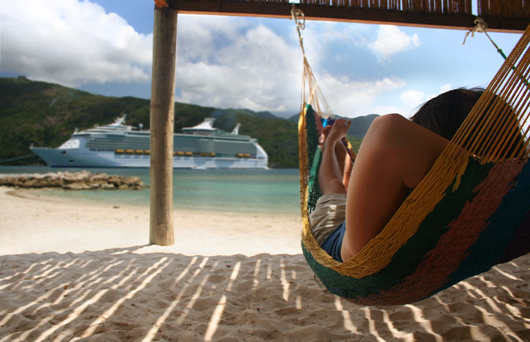 woman on hammock looking at cruise ship