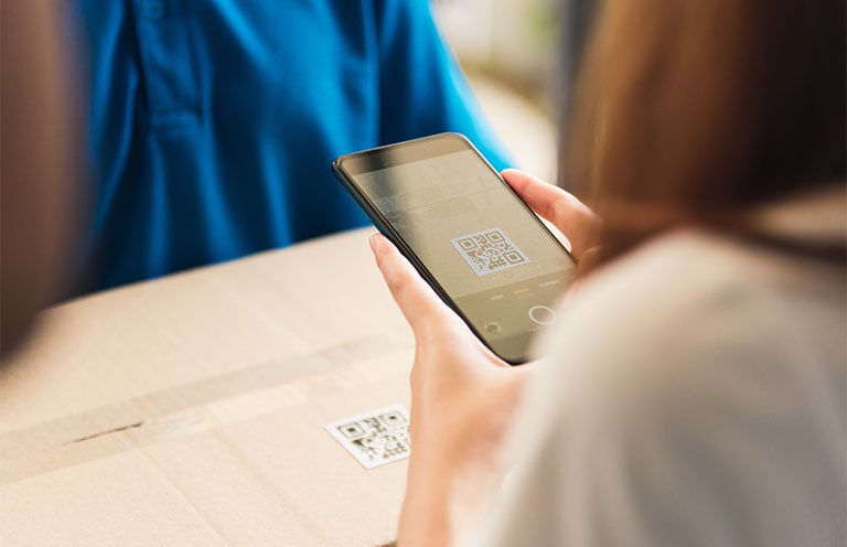woman scanning qr code with smartphone