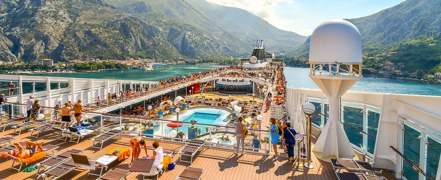 Crowded upper deck of the MSC Musica cruise ship as it pulls into the harbor of Kotor Montenegro on Boka or Bay of Kotor; Credit:Kirk Fisher